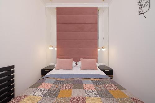 Beautiful & Stylish Apartaments Dietla with Air Conditioning by Renters في كراكوف: غرفة نوم مع سرير مع وسادتين ورديتين