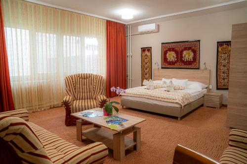 1 dormitorio con 1 cama y sala de estar en Hotel Dzsungel en Nyíregyháza