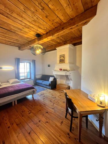 a living room with a bed and a table at Auberge Le Glacier Bleu in Mont-Dauphin