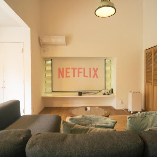 a living room with a netflix sign on the wall at HAZcottage in Makinohara