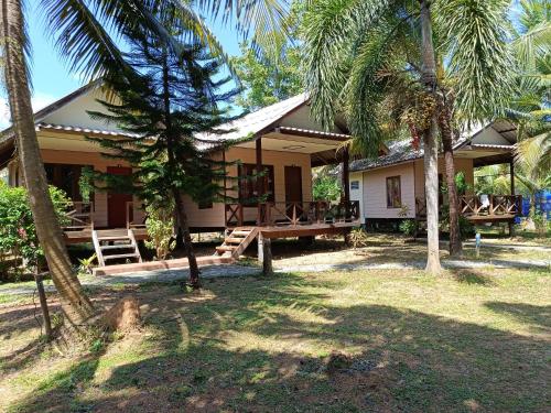 une maison avec des palmiers devant elle dans l'établissement Mangrove House Kohyao noi, à Ban Bang Chak