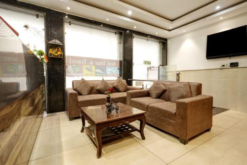 Sala de estar con 2 sofás y mesa de centro en Hotel IBY, en Nueva Delhi