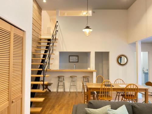 a dining room and kitchen with a staircase in a house at HAZcottage in Makinohara