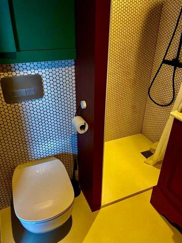 a bathroom with a white toilet and a yellow floor at Magnifique studio indépendant in Collonges-au-Mont-dʼOr