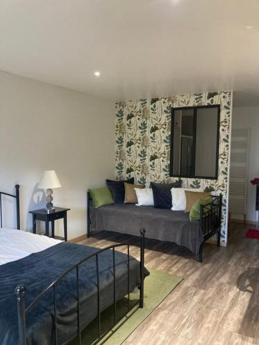 1 dormitorio con sofá y espejo en la pared en L'Oreade, en Amfreville-sur-Iton