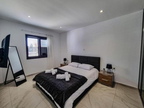 ein Schlafzimmer mit einem großen Bett mit zwei Kissen darauf in der Unterkunft Lavi La 2B, Sea Breeze, Paphos in Paphos City