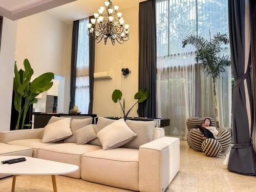 曼谷的住宿－summer villa 曼谷中心Asok&Thong Lor800平米海天别墅189/7，坐在客厅沙发上的女人