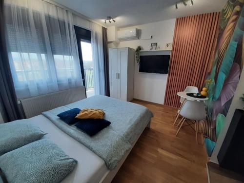 a bedroom with a bed with a cat laying on it at Apartman Luxor in Jagodina