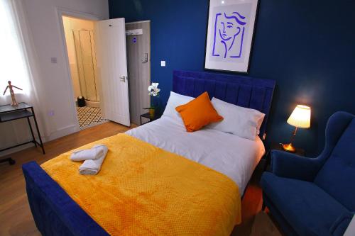 niebieska sypialnia z łóżkiem i niebieskim krzesłem w obiekcie St David w mieście Barrow in Furness