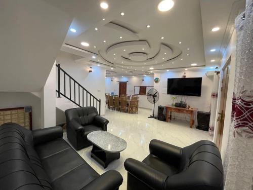 un soggiorno con divani e TV a schermo piatto di Villa de luxe avec piscine a Jaffna