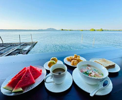 a table with plates of food and a cup of coffee at Meena Resort in Chanthaburi