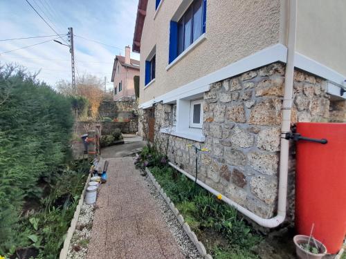 un mur en pierre à côté d'une maison dans l'établissement Studio paisible orsay, à Orsay