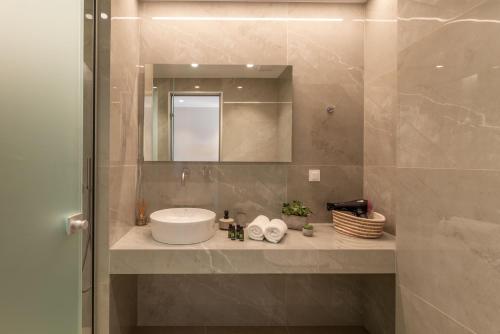 a bathroom with a sink and a mirror at Sofibel sivota suites in Syvota