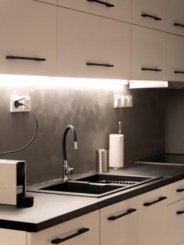 a kitchen with a sink and a stove top oven at Nueve / There's no place like home in Patra