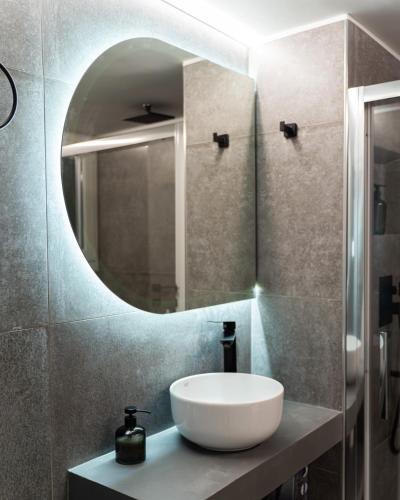 a bathroom with a white sink and a mirror at Nueve / There's no place like home in Patra