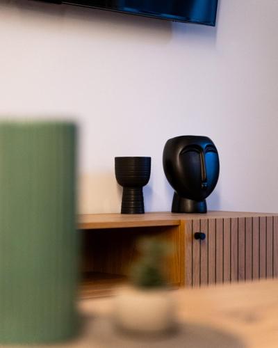 a wooden shelf with two black cups on it at Nueve / There's no place like home in Patra