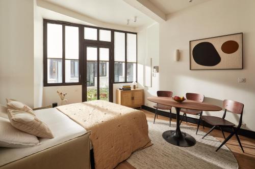 une chambre avec un lit, une table et des chaises dans l'établissement Cosy 1BR with outside space near Canal Saint Martin, à Paris