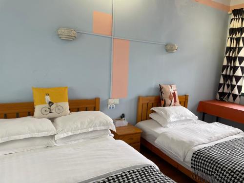 a bedroom with two beds and a bike on the wall at Changsha Fuxiangyuan International Hostel in Changsha