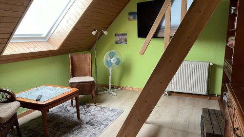 a living room with green walls and a fan at Blaues Haus-Urlaub mit Alpakas oder nur eine schöne Unterkunft in der schaalseergion 