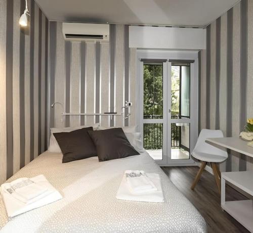 Schlafzimmer mit einem Bett, einem Tisch und einem Fenster in der Unterkunft Lux APT + piscina al Vittoriale degli Italiani in Gardone Riviera