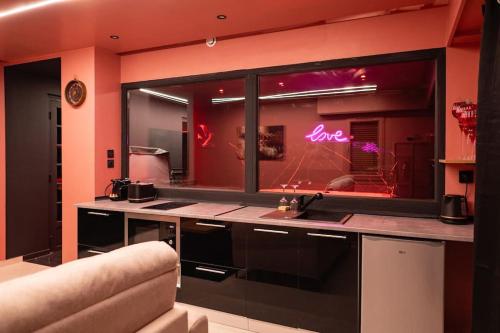 une cuisine avec un comptoir et une fenêtre avec des lampes de néon dans l'établissement L’alcôve de la tentation, à Villeurbanne