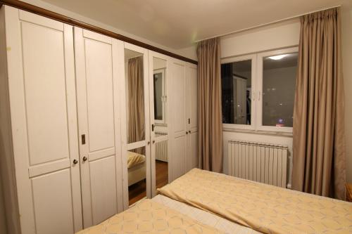 ein Schlafzimmer mit weißen Schränken und einem Bett darin in der Unterkunft Giovanni appartment in Skopje