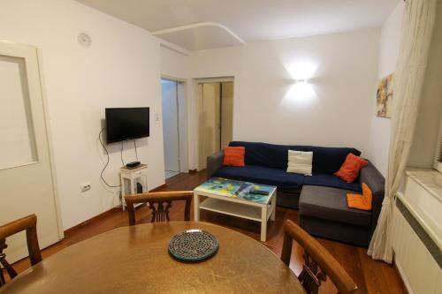 ein Wohnzimmer mit einem blauen Sofa und einem Tisch in der Unterkunft Giovanni appartment in Skopje