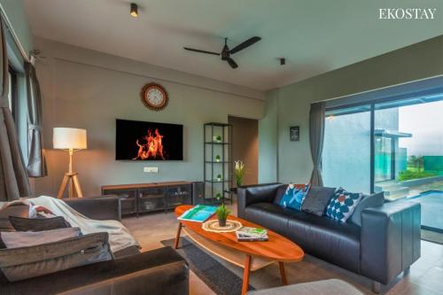 a living room with a couch and a table at EKOSTAY - Neptune Villa in Igatpuri