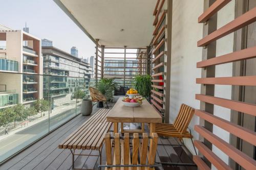 City Walk - 2BR with Terrace - CityApartmentStay في دبي: شرفة الشقة مع طاولة وكراسي خشبية