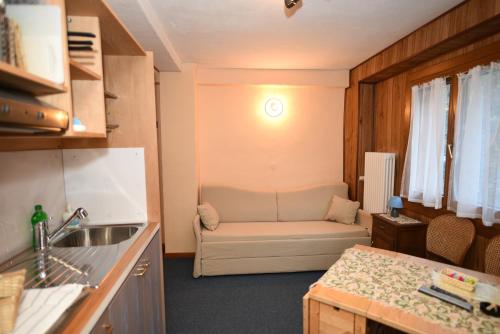 a kitchen with a couch in a small room at Hotel Genzianella in Champoluc