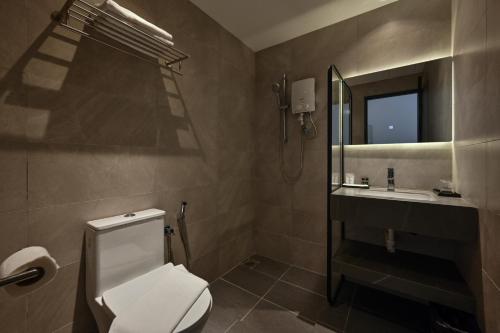 a bathroom with a toilet and a sink and a mirror at Macalister 288 in George Town