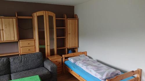 een slaapkamer met een bank, een bed en een kast bij Ferienwohnung Angelburg - Marburg Biedenkopf mit Balkon und Badewanne in Gönnern