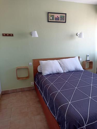 une chambre avec un lit avec une couette bleue dans l'établissement Le Petit Canet, à Canet