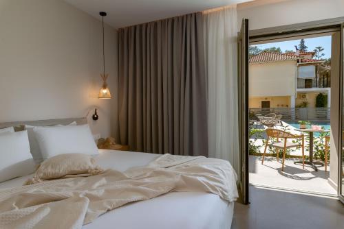 1 dormitorio con cama y vistas a un patio en Sofibel sivota suites, en Sivota