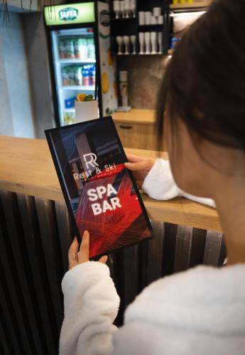 a woman is reading a book at a store at Rest&Ski Spa Resort in Bukovel