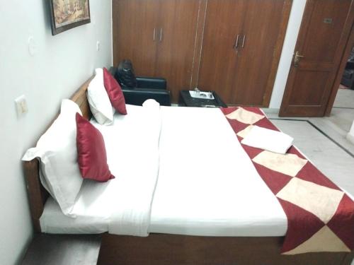 1 dormitorio con 1 cama con almohadas rojas y blancas en Hotel Heritage By ''ADA'', en Noida