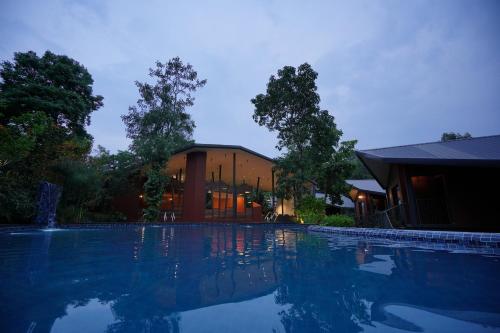a swimming pool in front of a house at Vyna Hillock Resort and Spa in Vythiri