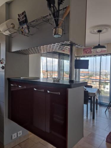 une cuisine avec un comptoir noir et une table dans l'établissement Le Petit Canet, à Canet