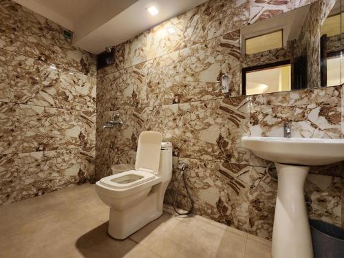 een badkamer met een toilet en een wastafel bij Hotel Savera in Udaipur