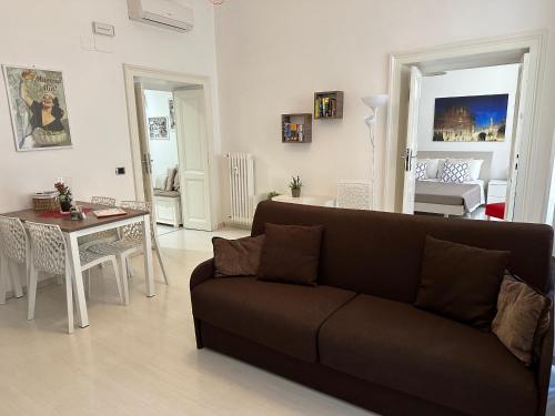 Rome Holiday Home في روما: غرفة معيشة مع أريكة وطاولة