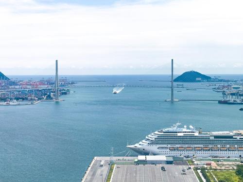 a cruise ship in a harbor with a bridge at Brown Suites Busan Station in Busan