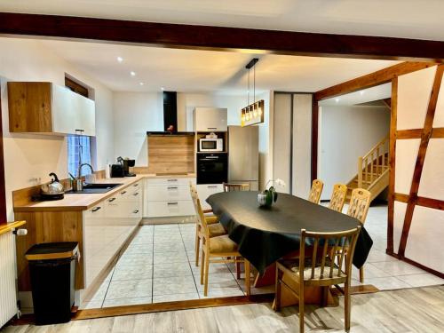 eine Küche mit einem Tisch und Stühlen in einer Küche in der Unterkunft Gîte de la Fontaine Charmante maison au cœur de Beblenheim - Route des vins in Beblenheim