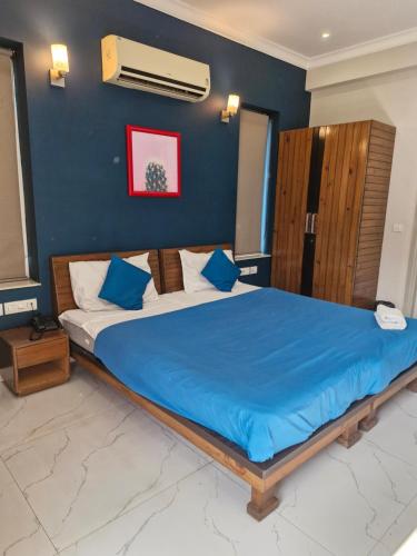 a bedroom with a large bed with a blue blanket at Medenta square 39 in Gurgaon