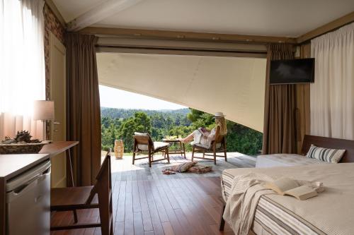 a hotel room with two beds and a large window at iHouseVILLAGE in Polykhrono