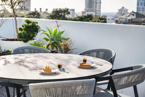 a table with two plates of food on a balcony at KG4 LUX Apartments in Tel Aviv