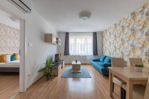 ein Wohnzimmer mit einem blauen Sofa und einem Tisch in der Unterkunft Prince downtown apartments with free parking in Budapest