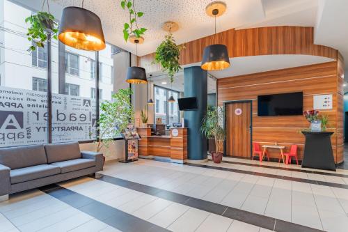 - un hall avec un canapé et une télévision dans un bâtiment dans l'établissement Appart'City Confort Le Mans Centre, au Mans