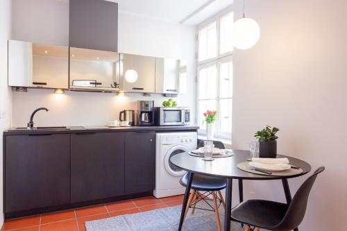 een keuken met een kleine tafel en een magnetron bij Gildi Apartment in Tartu
