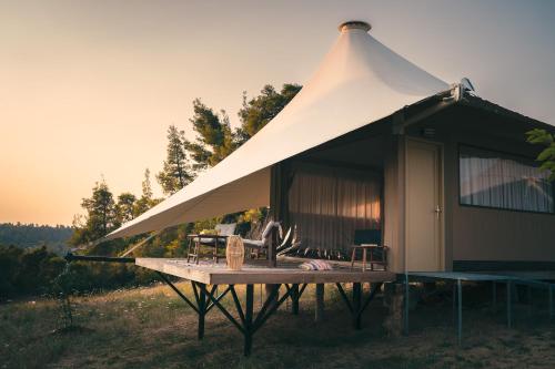 a tent with chairs and a table in a field at iHouseVILLAGE in Polykhrono