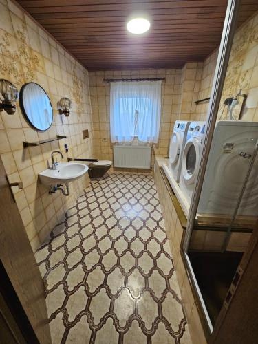a bathroom with a sink and a washing machine at Gästehaus Weißes Lamm - MONTEURZIMMER in Nordhalben